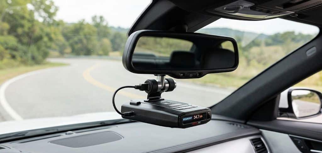 Escort radar detector mounted below a rear view mirror