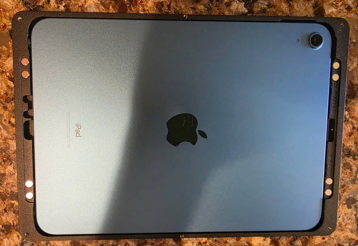 Displine Companion Wall 2.0 Frame with iPad Blue Apple iPad seated face-down inside the black Displine Companion Wall 2.0 aluminum frame showing precision corner fit